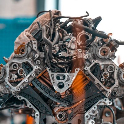 ecovel-auto A close-up of a mechanical car engine showcasing intricate details and components in a workshop setting.